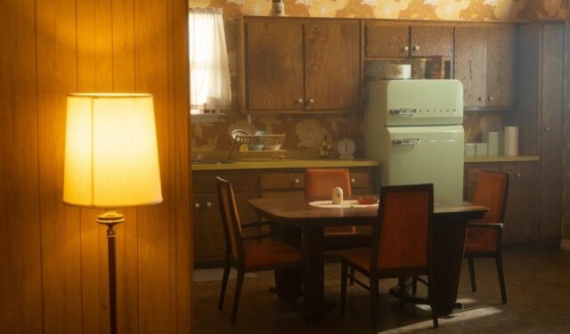 Warmly lit vintage kitchen and dining area with wood paneling